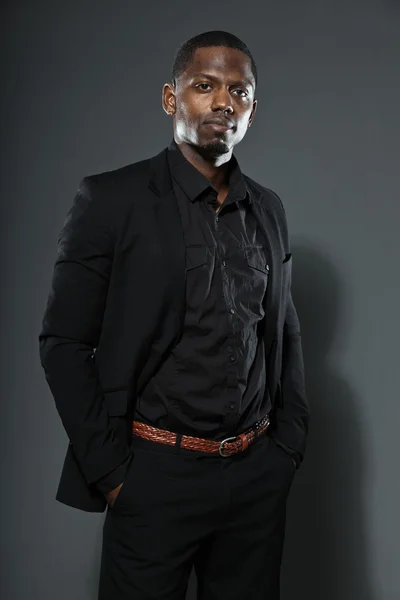 Cool black american man in dark suit. Studio fashion shot isolated on grey background. Royalty Free Stock Photos