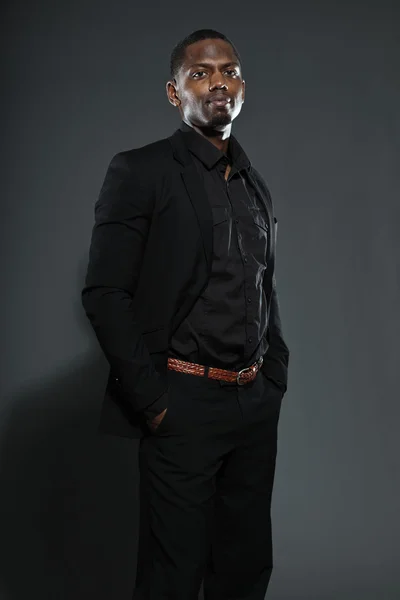 Cool black american man in dark suit. Studio fashion shot isolated on grey background. Stock Photo