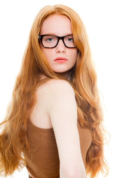 Bella ragazza con lunghi capelli rossi che indossa camicia marrone e occhiali vintage. Studio di moda girato isolato su sfondo bianco . — Foto Stock