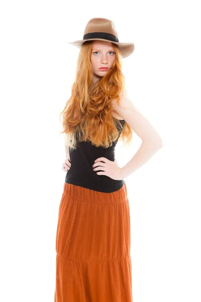 Belle fille aux longs cheveux rouges portant une chemise noire et une robe marron et un chapeau marron. Studio de mode tourné isolé sur fond blanc . — Photo
