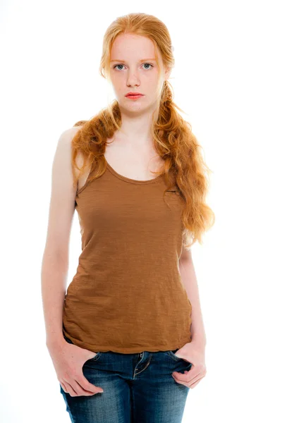 Söt flicka med långa röda hår bär brun skjorta och jeans. naturliga skönhet. mode studio skott isolerade på vit bakgrund. — Stockfoto