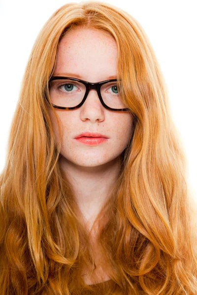Söt flicka med långa röda hår bär brun skjorta och vintage glas. mode studio skott isolerade på vit bakgrund. — Stockfoto