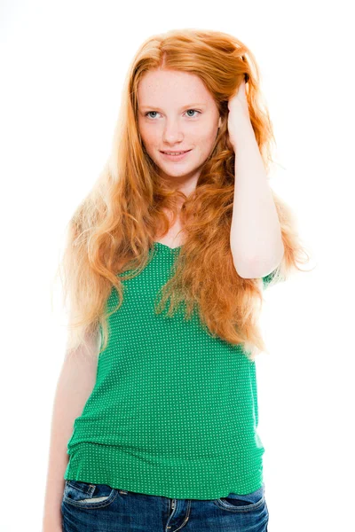 Usmívající se hezká holka s dlouhé červené vlasy, nosí zelené triko. módní studio zastřelil izolované na bílém pozadí. — Stock fotografie