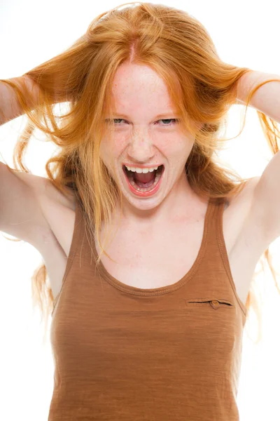 Menina bonita com cabelos longos ruivos vestindo camisa marrom. Um olhar furioso. Estúdio de moda tiro isolado no fundo branco . — Fotografia de Stock