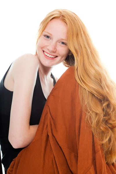 Улыбающаяся красивая девушка с длинными рыжими волосами в черной рубашке и коричневом платье. Студия моды сняла на белом фоне . — стоковое фото