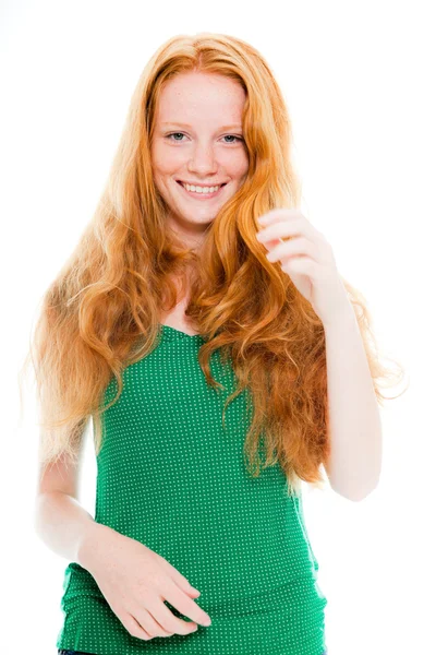 Smiling pretty girl with long red hair wearing green shirt. Fashion studio shot isolated on white background. — Stock Photo, Image