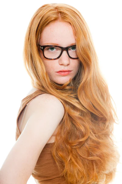 Bella ragazza con lunghi capelli rossi che indossa camicia marrone e occhiali vintage. Studio di moda girato isolato su sfondo bianco . — Foto Stock