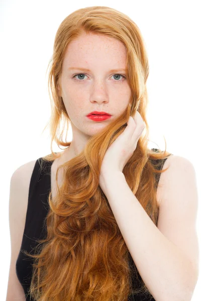 Pěkná dívka s dlouhé červené vlasy a rtěnku na sobě černé tričko. módní studio zastřelil izolované na bílém pozadí. — Stock fotografie
