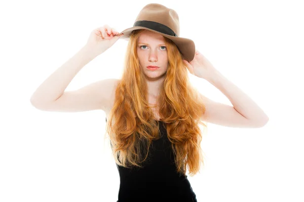 Hübsches Mädchen mit langen roten Haaren, schwarzem Hemd und braunem Hut. Modestudio isoliert auf weißem Hintergrund gedreht. — Stockfoto