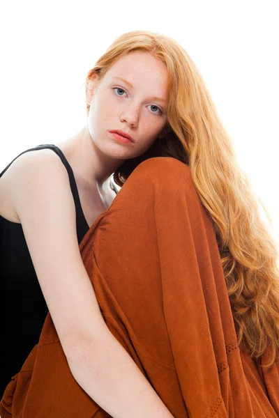Pretty girl with long red hair wearing black shirt and brown dress. Fashion studio shot isolated on white background. — Stock Photo, Image