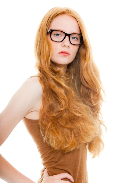 Csinos lány hosszú vörös haja barna ing és vintage szemüveget visel. divat stúdió felvétel a elszigetelt fehér háttér. — Stock Fotó