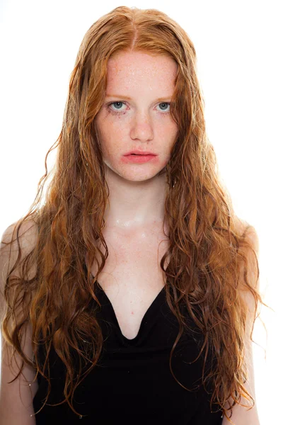 Pretty girl with long red hair wearing black shirt. Wet hair and face looking sad. Fashion studio shot isolated on white background. — Stock Photo, Image