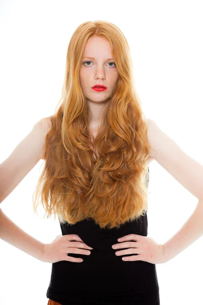 Mooi meisje met lange rode haren en het dragen van lippenstift zwart shirt. mode studio opname geïsoleerd op witte achtergrond. — Stockfoto