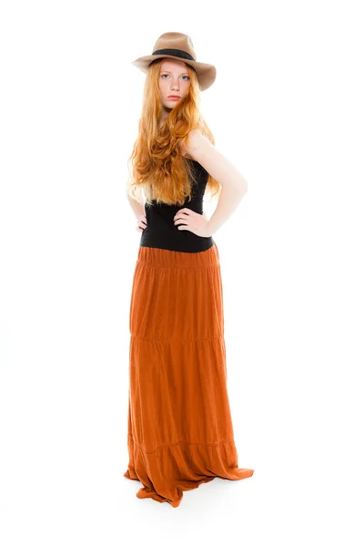 Handsome girl with long red hair wearing black shirt and brown dress and brown hat. Fashion studio shot isolated on white background. — Stock Photo, Image