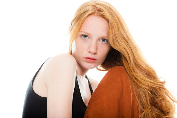 Csinos lány hosszú vörös haja fekete inget és barna ruhát visel. divat stúdió felvétel a elszigetelt fehér háttér. — Stock Fotó