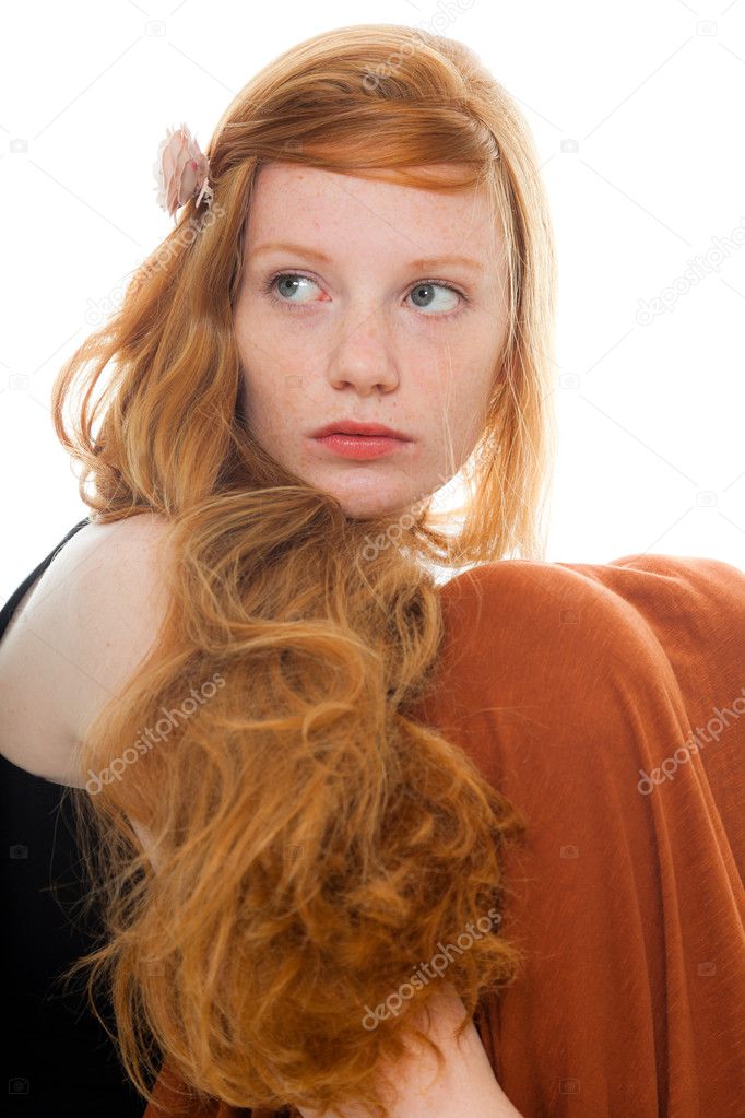 Pretty girl with long red hair wearing black shirt and brown dress. Fashion studio shot isolated on white background.