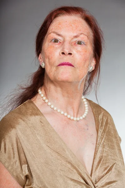 Portrét dobré starší ženu s expresivní tváří ukazovat emoce. vztek. jednají mladí. Studio záběr izolované na šedém pozadí. — Stock fotografie