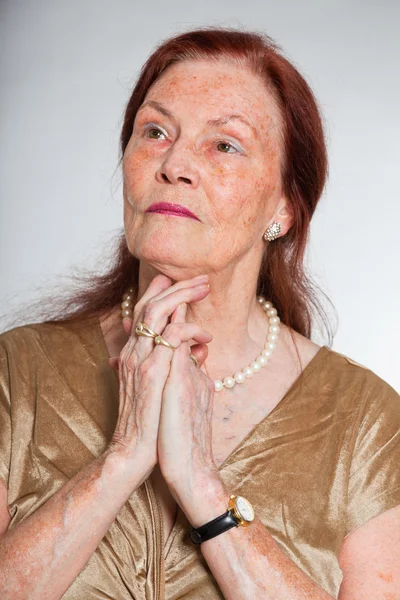 Портрет добродушної старшої жінки з виразним обличчям, що демонструє емоції. Мислення і надія. Поводитися молодо. Студійний знімок ізольовано на сірому фоні . — стокове фото