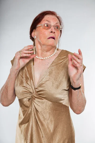 Retrato de boa aparência mulher idosa vestindo óculos com rosto expressivo mostrando emoções. Assustado e assustado. A agir jovem. Estúdio tiro isolado em fundo cinza . — Fotografia de Stock