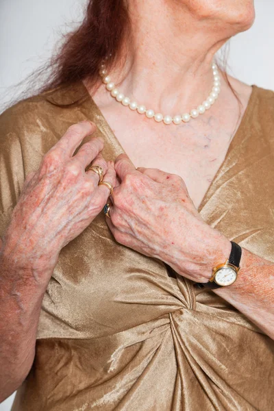 Närbild av händerna på äldre kvinna som bär en klocka och ring. Studio skott. — Stockfoto