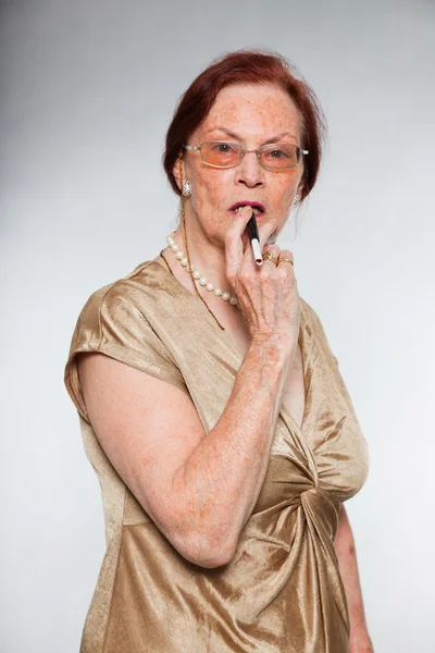 감정을 보여주는 표현 얼굴로 안경을 좋은 찾고 고위 여자의 초상화. 담배 흡연. 젊은 행동. 스튜디오 촬영에 고립 된 회색 배경. — 스톡 사진