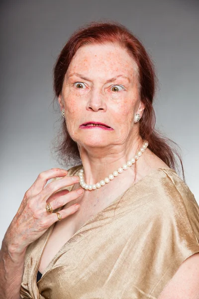 Portrait de belle femme âgée au visage expressif montrant des émotions. En colère. Agir jeune. Studio tourné isolé sur fond gris . — Photo