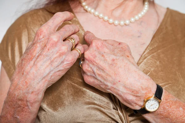Closeup of hands of senior woman wearing a watch and ring. Studio shot. — Stock Photo, Image