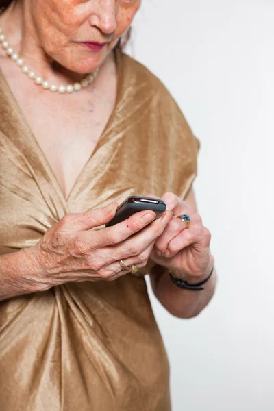 Portrét dobré starší ženu s expresivní tváří ukazovat emoce. volání s mobil. jednají mladí. Studio záběr izolované na šedém pozadí. — Stock fotografie