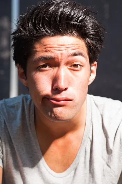 Urban asiatiska mannen att göra roliga ansikte. Snygg. cool kille. klädd i grå tröja. — Stockfoto