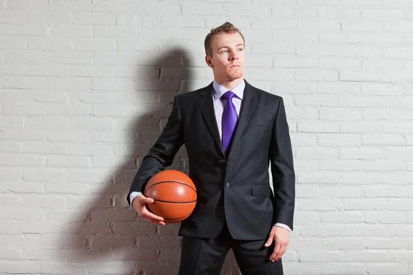 Uomo d'affari con pallacanestro. Bel giovanotto con i capelli biondi corti. Palestra coperta . — Foto Stock