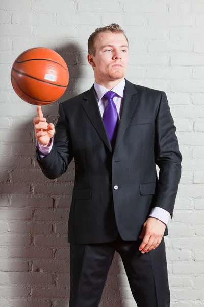 Hombre de negocios con baloncesto. Joven guapo con el pelo corto y rubio. Gimnasio interior . —  Fotos de Stock