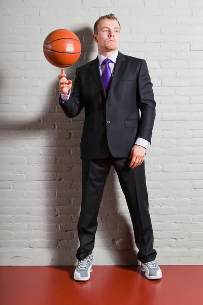 Obchodní muž s basketbal. dobře vypadající mladý muž s krátkými blond vlasy. posilovna, indoor. — Stock fotografie