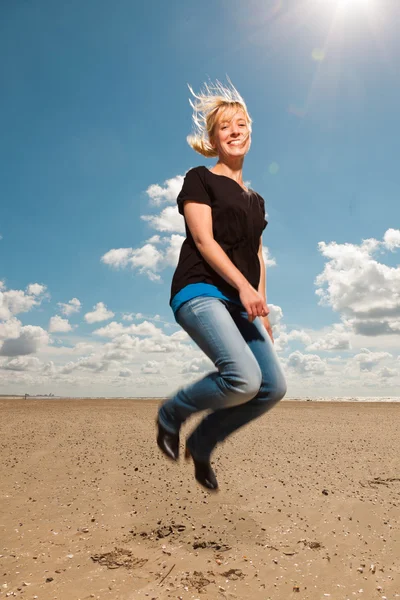 Feliz mujer rubia bonita en la playa. Disfrutando de la naturaleza. Cielo nublado azul. Usar suéter negro . — Foto de Stock