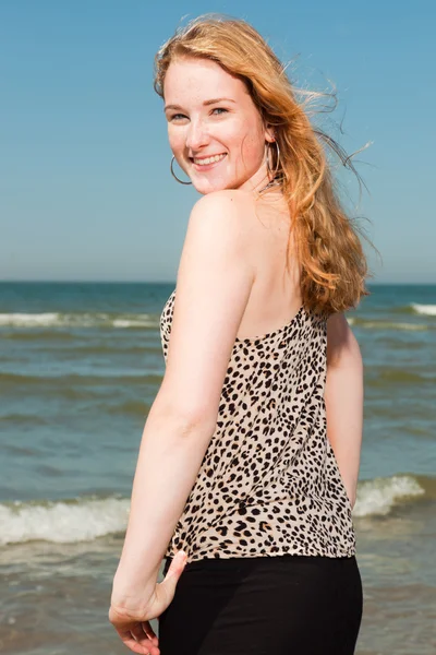 Gelukkig mooi meisje met lang rood haar genieten van de verfrissende strand op hete zomers dag. duidelijke blauwe hemel. — Stockfoto