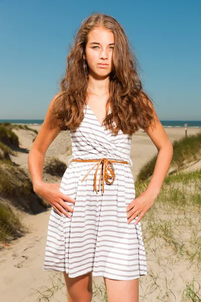 Gelukkig mooi meisje met lange bruin haar zandduinen in de buurt van het strand genieten op hete zomers dag. duidelijke blauwe hemel. — Stockfoto