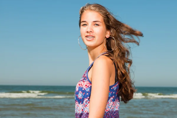Happy pretty girl with long brown hair enjoying the refreshing beach on hot summers day. Clear blue sky. — Stock Photo, Image