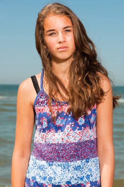 Ευτυχισμένο το όμορφο κορίτσι με μακριά καστανά μαλλιά, απολαμβάνοντας δροσιστικά παραλία την ημέρα καλοκαίρια. σαφή μπλε ουρανό. — Φωτογραφία Αρχείου