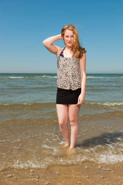 Happy pretty girl with long red hair enjoying the refreshing beach on hot summer day. Ясное голубое небо . — стоковое фото