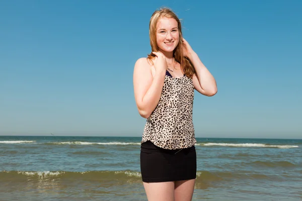 Gelukkig mooi meisje met lang rood haar genieten van de verfrissende strand op hete zomers dag. duidelijke blauwe hemel. — Stockfoto