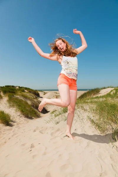 Feliz chica bonita con el pelo largo y rojo disfrutando de dunas de arena cerca de la playa en el día de los veranos calurosos. Cielo azul claro . —  Fotos de Stock