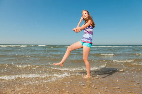 Glückliches hübsches Mädchen mit langen braunen Haaren, das an heißen Sommertagen den erfrischenden Strand genießt. blauer Himmel. — Stockfoto