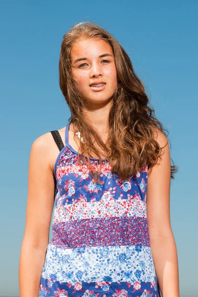 Menina bonita feliz com cabelos castanhos longos desfrutando ao ar livre no dia de verão quente. Céu azul claro . — Fotografia de Stock
