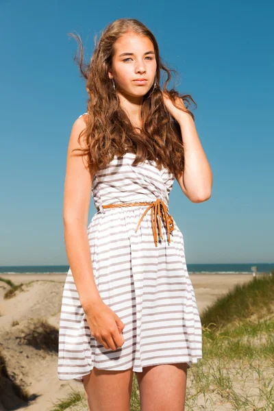 Ευτυχισμένο το όμορφο κορίτσι με μακριά καστανά μαλλιά, απολαμβάνοντας αμμόλοφους, κοντά στην παραλία για την ημέρα καλοκαίρια. σαφή μπλε ουρανό. — Φωτογραφία Αρχείου
