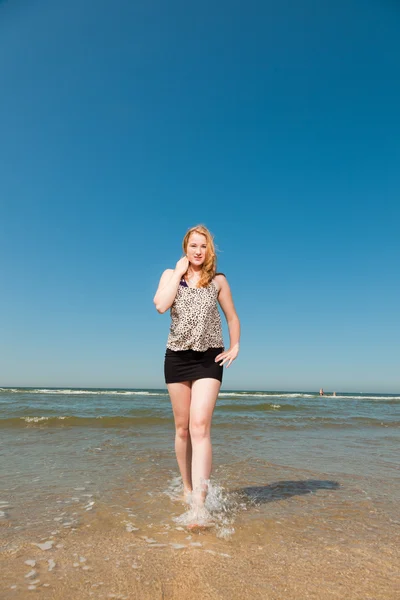 Szczęśliwy ładna dziewczyna z długie brązowe włosy, korzystających z wydm, w pobliżu plaży w upalny dzień lata. sobie singlasses. jasne, Błękitne niebo. — Zdjęcie stockowe