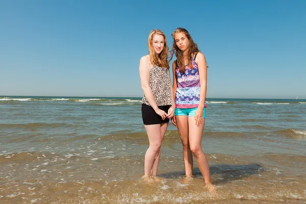 两个漂亮女孩玩和享受的刷新在炎热的日子。清除蓝蓝的天空。在海滩上很开心. — 图库照片