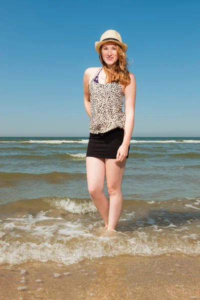 快乐的漂亮女孩与红色的长头发和帽子热的夏天一天享受清凉的海滩。清澈的天空. — 图库照片