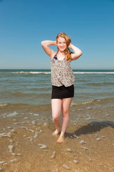 Jolie jolie fille aux longs cheveux roux profitant de la plage rafraîchissante lors d'une chaude journée d'été. Ciel bleu clair . — Photo