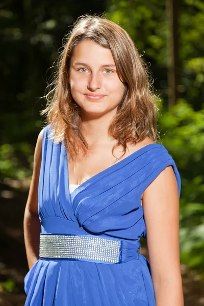 Csinos, fiatal nő, hosszú barna haja élvezi természet erdőben. zöld lomb háttér. kék ruhát visel. — Stock Fotó