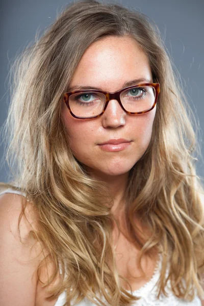 Mulher bonita com cabelo castanho longo usando óculos. Estúdio de moda tiro isolado em fundo cinza . — Fotografia de Stock