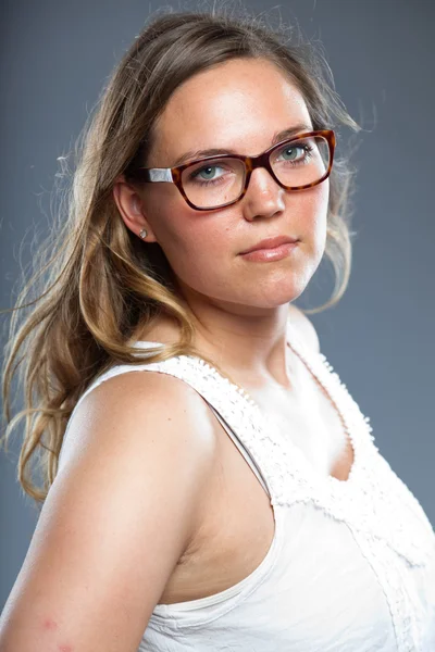 Pretty woman with long brown hair wearing glasses. Fashion studio shot isolated on grey background. — Stock Photo, Image